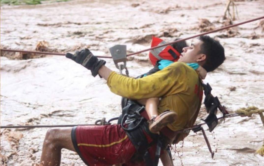 Una de las imágenes que dio la vuelta al mundo: un rescatista del Cuerpo de Bomberos salvó a varios menores este 5 de noviembre en las zonas bajas del valle de Sula.