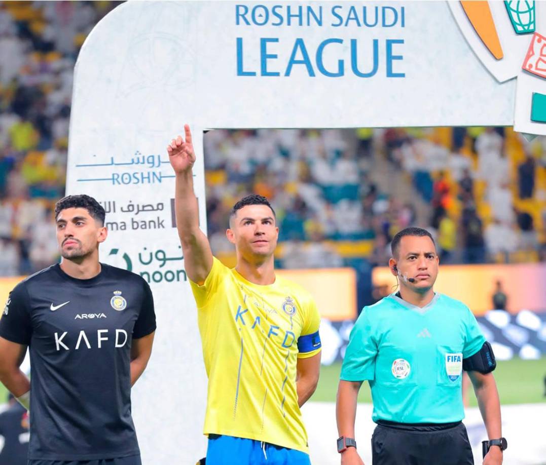 El árbitro asistente hondureño Christian Ramírez junto a Cristiano Ronaldo antes del inicio del partido.