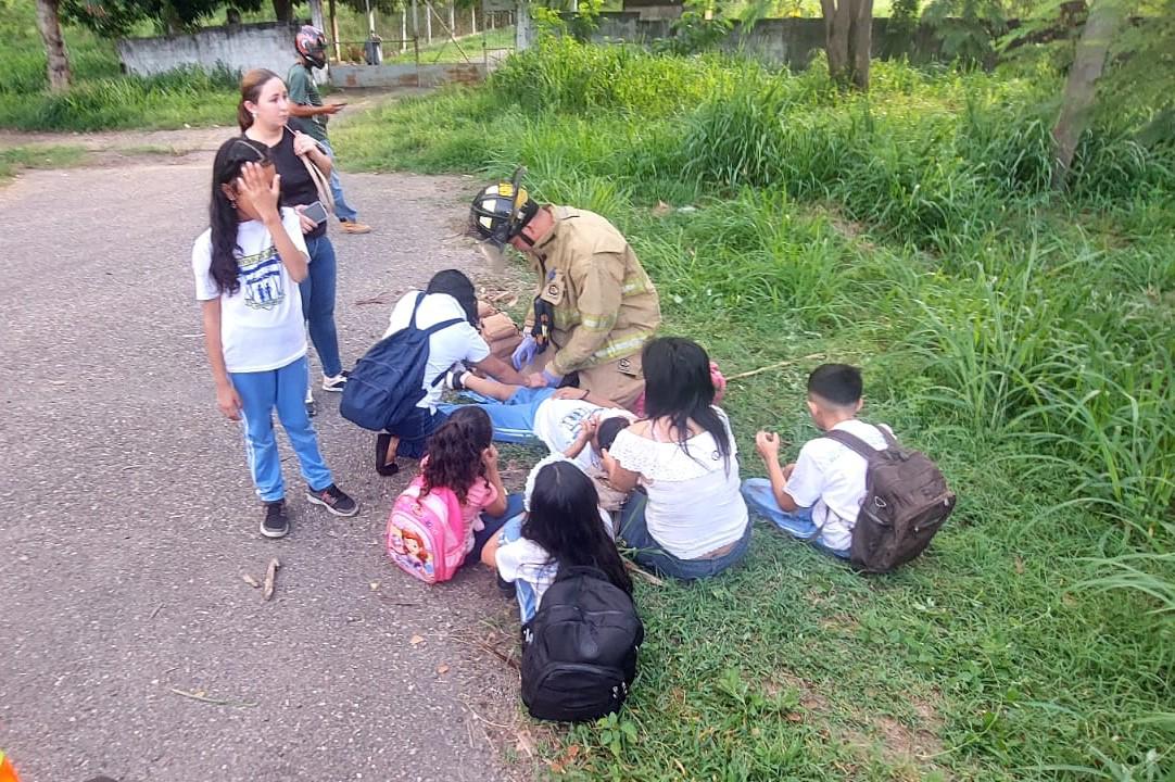 Un miembro del Cuerpo de Bomberos auxilia a escolares que resultaron lesionados en el accidente en Villanueva, Cortés.