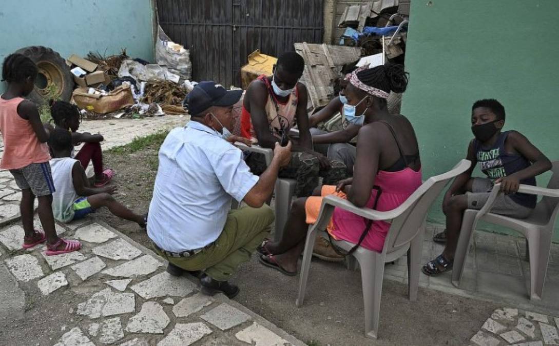Un policía local de Trojes conversa con migrantes haitianos, en la oficina de Migración del municipio oriental. Fotos: AFP