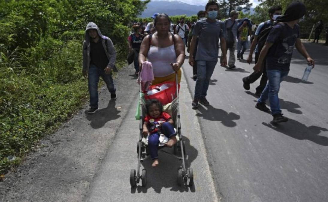 Una migrante hondureña empuja a un niño en un carrito en Entre Ríos, Guatemala. Foto AFP