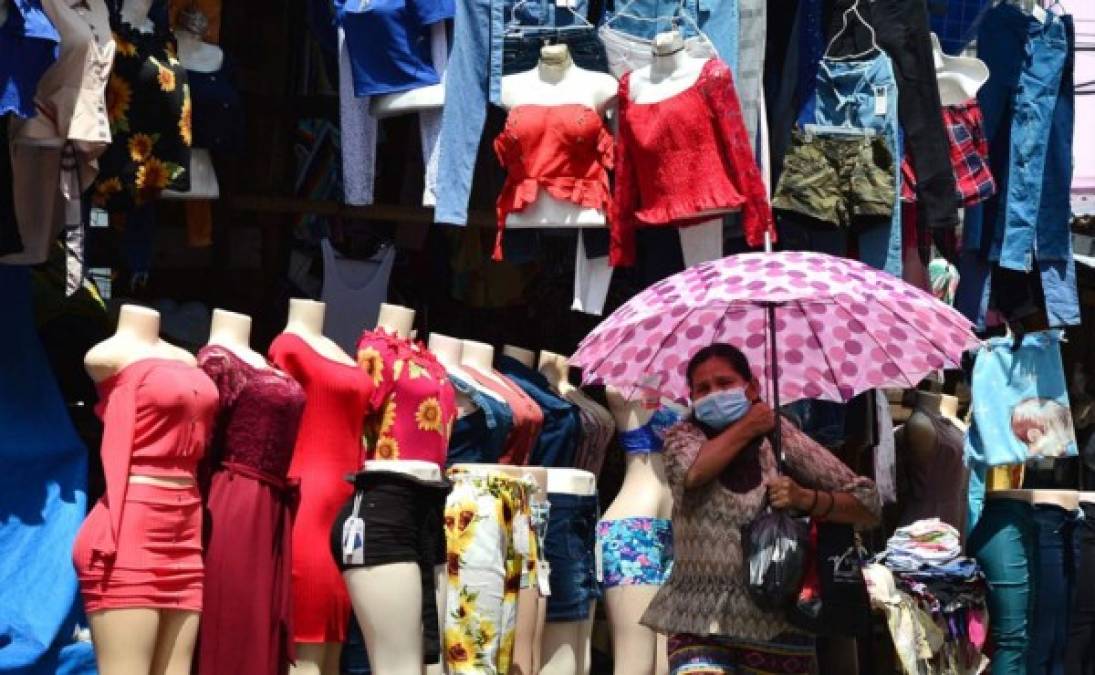Una mujer usa una máscara facial durante la pandemia de COVID-19 en un mercado callejero en Tegucigalpa. Foto AFP