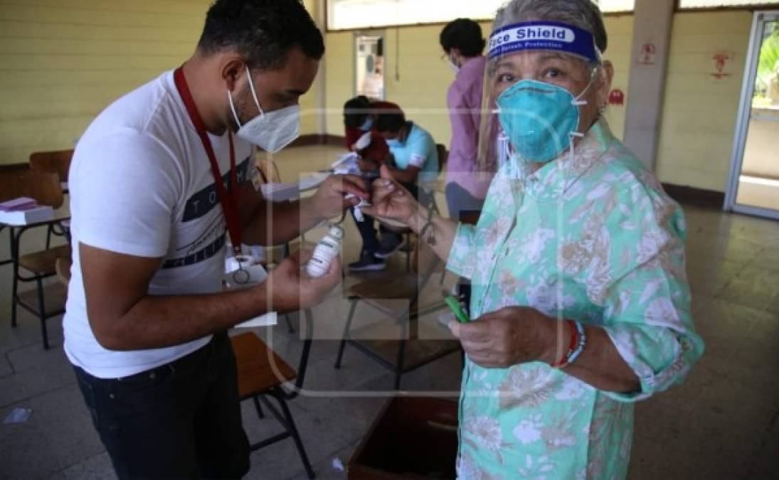 Una hondureña de la tercera edad manchándose el dedo tras ejercer su voto.