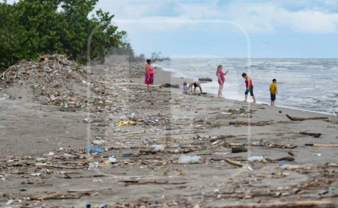 Turistas de Cuyamel apartan la basura procedente de Guatemala.