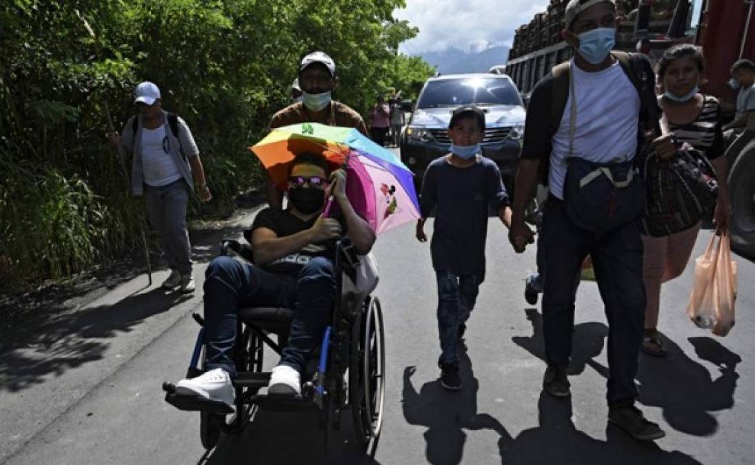 Un migrante hondureño, parte de una caravana que se dirige a Estados Unidos, es empujado en una silla de ruedas en Entre Ríos, Guatemala, luego de cruzar la frontera con Honduras. Foto AFP