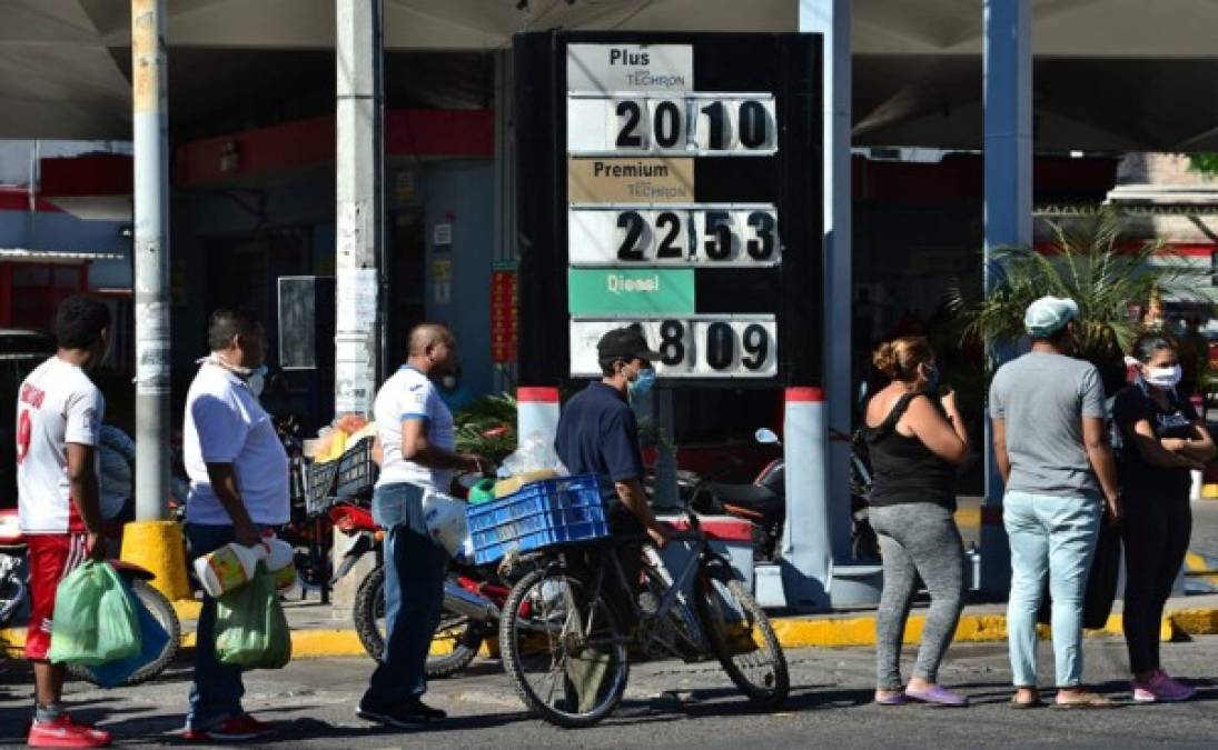 La gente hace cola para comprar aceite de queroseno en una estación de combustible en Tegucigalpa. Foto AFP