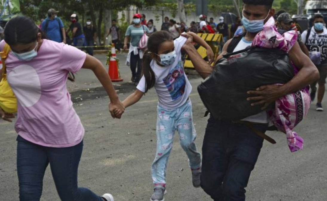 Una pareja de migrantes hondureños y su hija atraviesan una cerca policial para ingresar a Guatemala en su camino a los Estados Unidos. Foto AFP