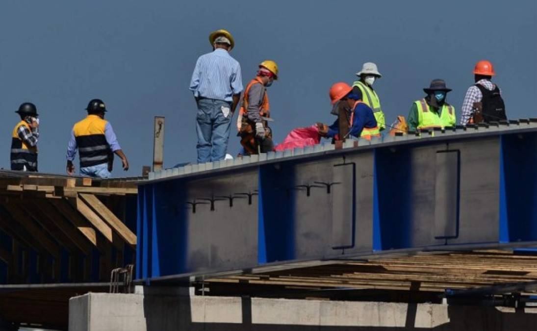 Trabajadores en el sitio de construcción de un puente en Tegucigalpa. Foto AFP