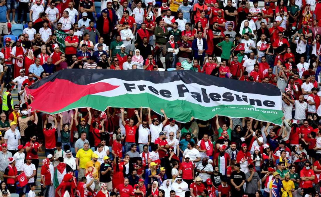 La bandera de Palestina se ve entre los aficionados de Túnez en las gradas durante el partido ante Australia.