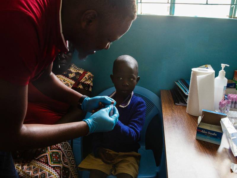 Tomando una muestra de sangre de Emmanuel Amyorit, de 7 años, en una clínica en Busia, Kenia, para detectar malaria.