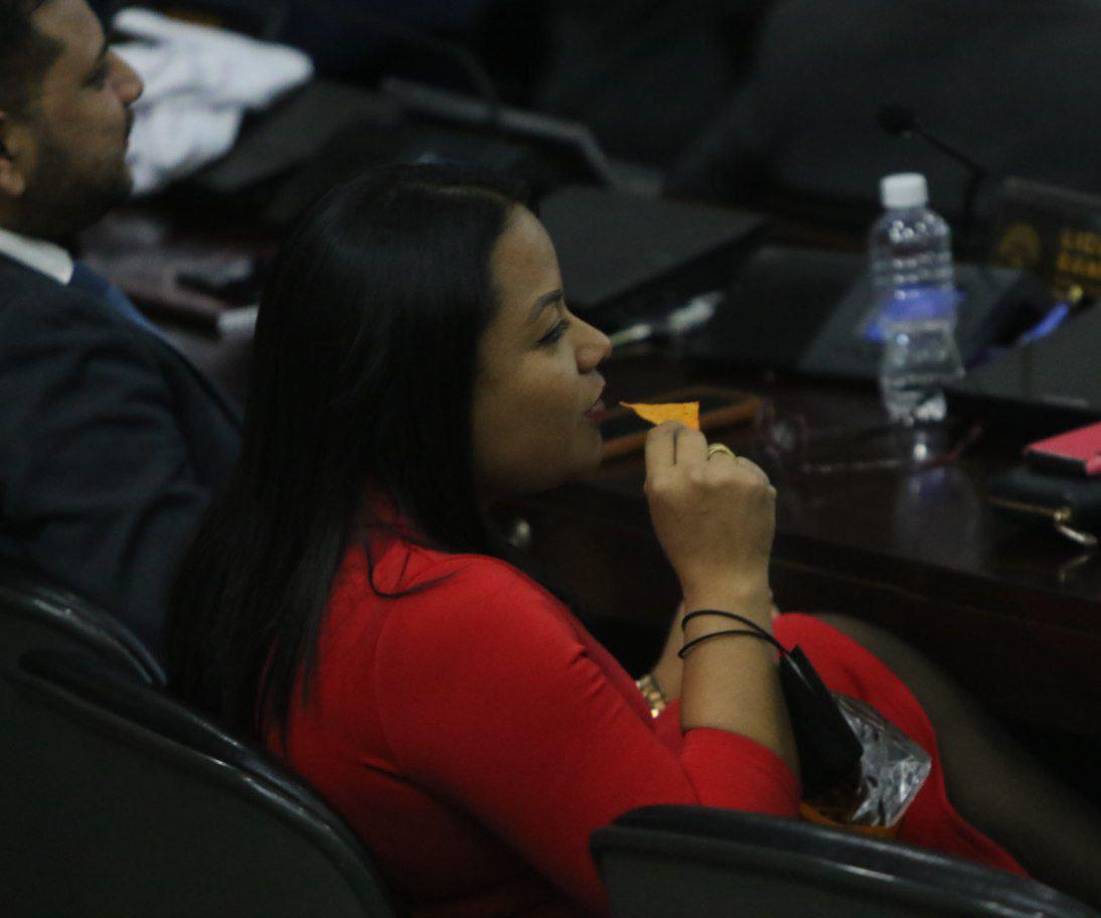 Una diputada de Libre disfruta de un snack mientras termina la sesión del congreso Nacional de Honduras.