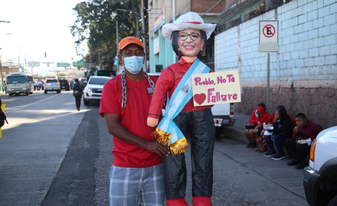 Un ciudadano con un monigote de la presidenta de Honduras en las afueras del estadio.