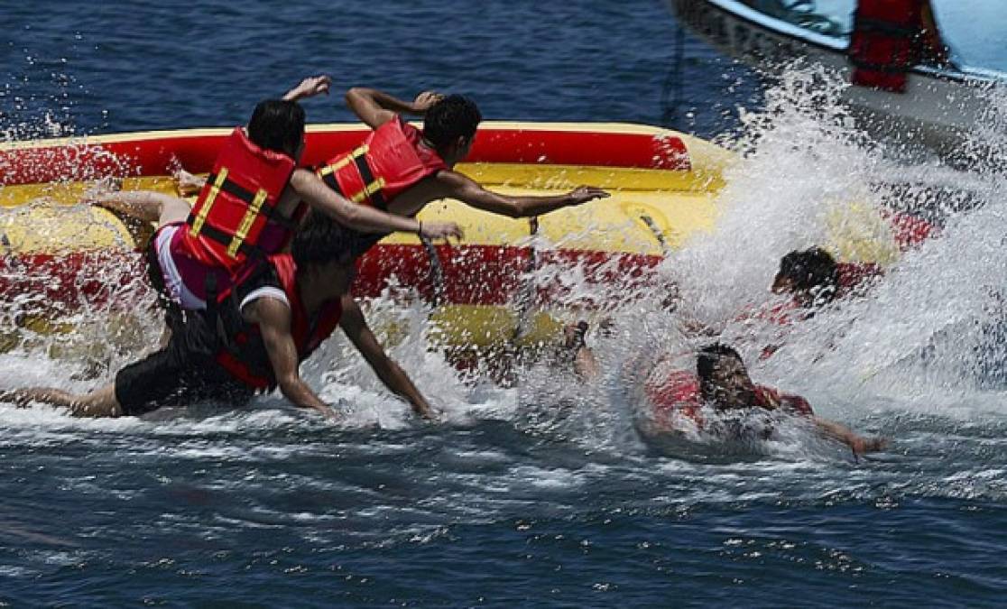 Un grupo de amigos disfrutó al subirse y posteriormente caer de la famosa 'Banana', una de las atracciones principales durante el verano en Honduras. (AFP)