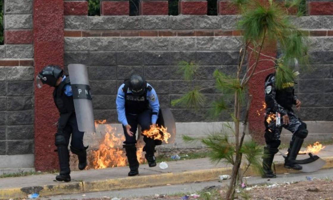 Estudiantes de la Unah que exigen la renuncia de la rectora Julieta Castellanos se enfrentaron hoy durante una protesta a la Policía Nacional, que utilizó bombas lacrimógenas y cañones de agua para dispersarlos. AFP<br/>