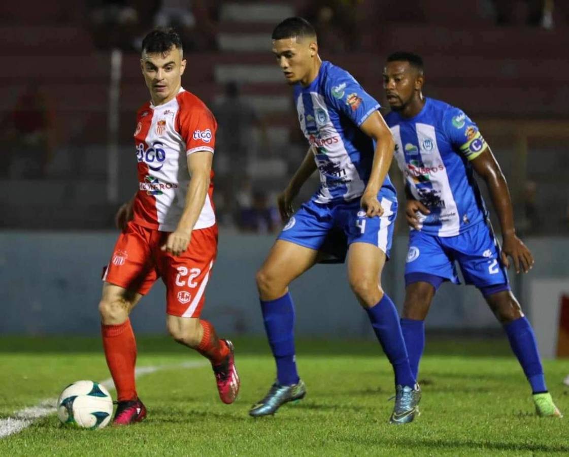 Brian Visser, del Vida, siendo marcado por Júnior García y José Velásquez.