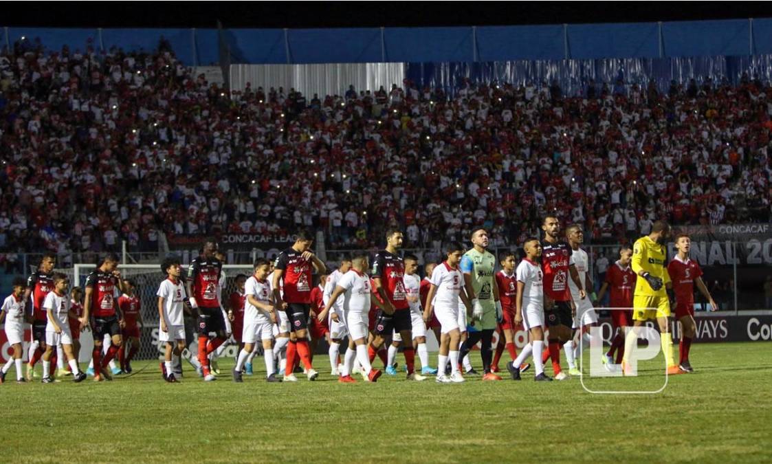 Los equipos titulares de Olimpia y Alajuelense saliendo a la cancha del estadio Nacional Chelato uclés de la mano de niños.