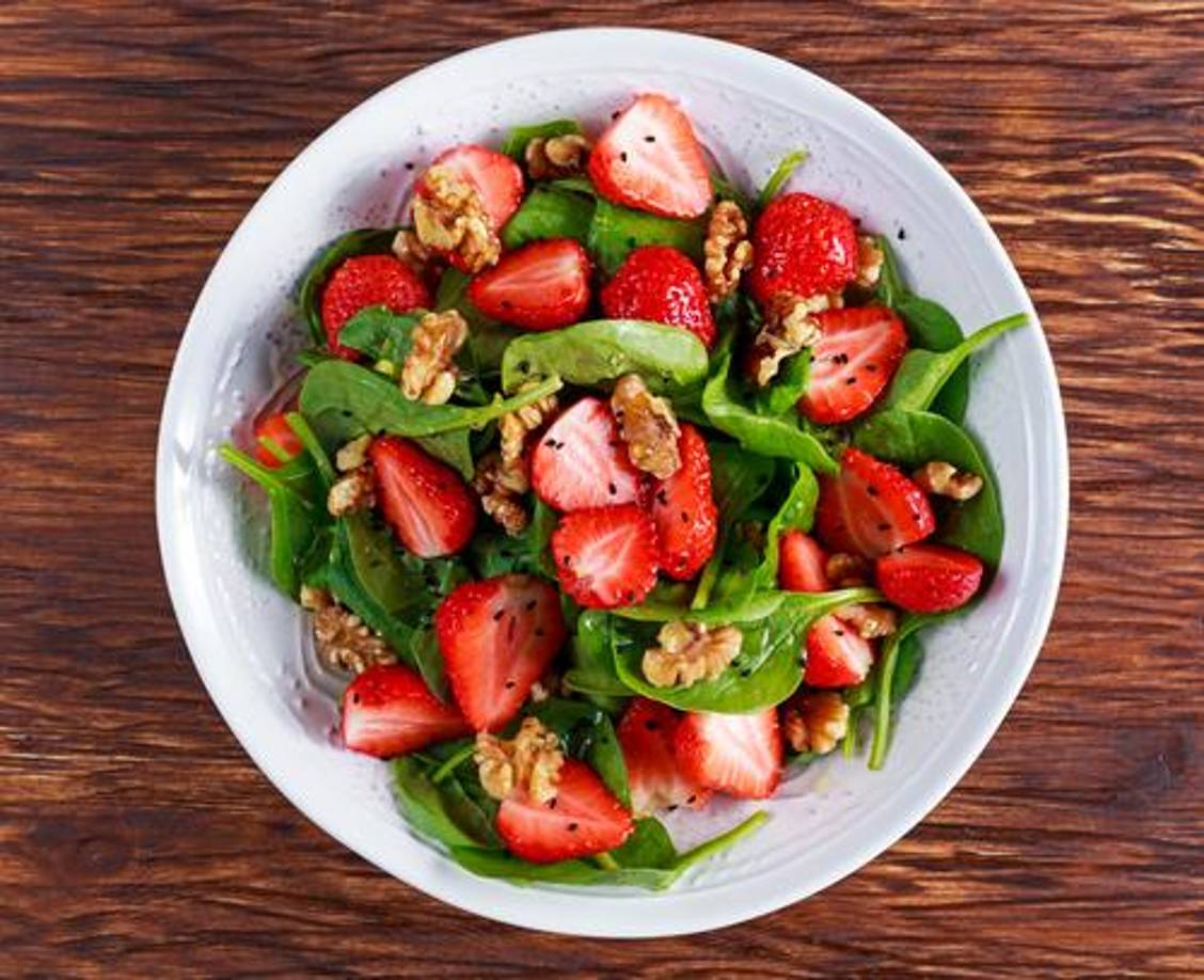 9. Ensalada de espinacas y fresas: Esta ensalada combina espinacas frescas con fresas, almendras tostadas y un aderezo balsámico. Es una opción ligera y refrescante para acompañar platos más pesados.