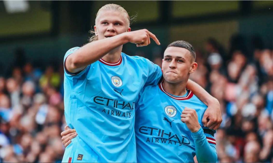 Erling Haaland señalando a la otra figura del partido, Phil Foden, autor de un triplete.