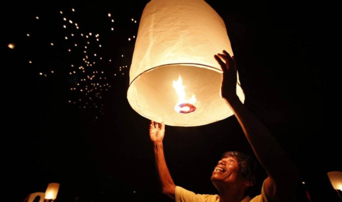 Un hombre enciende un farolillo durante una ceremonia en recuerdo a las víctimas del tsunami de 2004 en Baan Nam Khem en Tailandia.