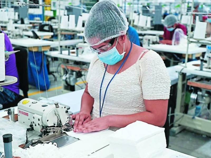 Operadora de maquila haciendo costuras | Fotografía de archivo