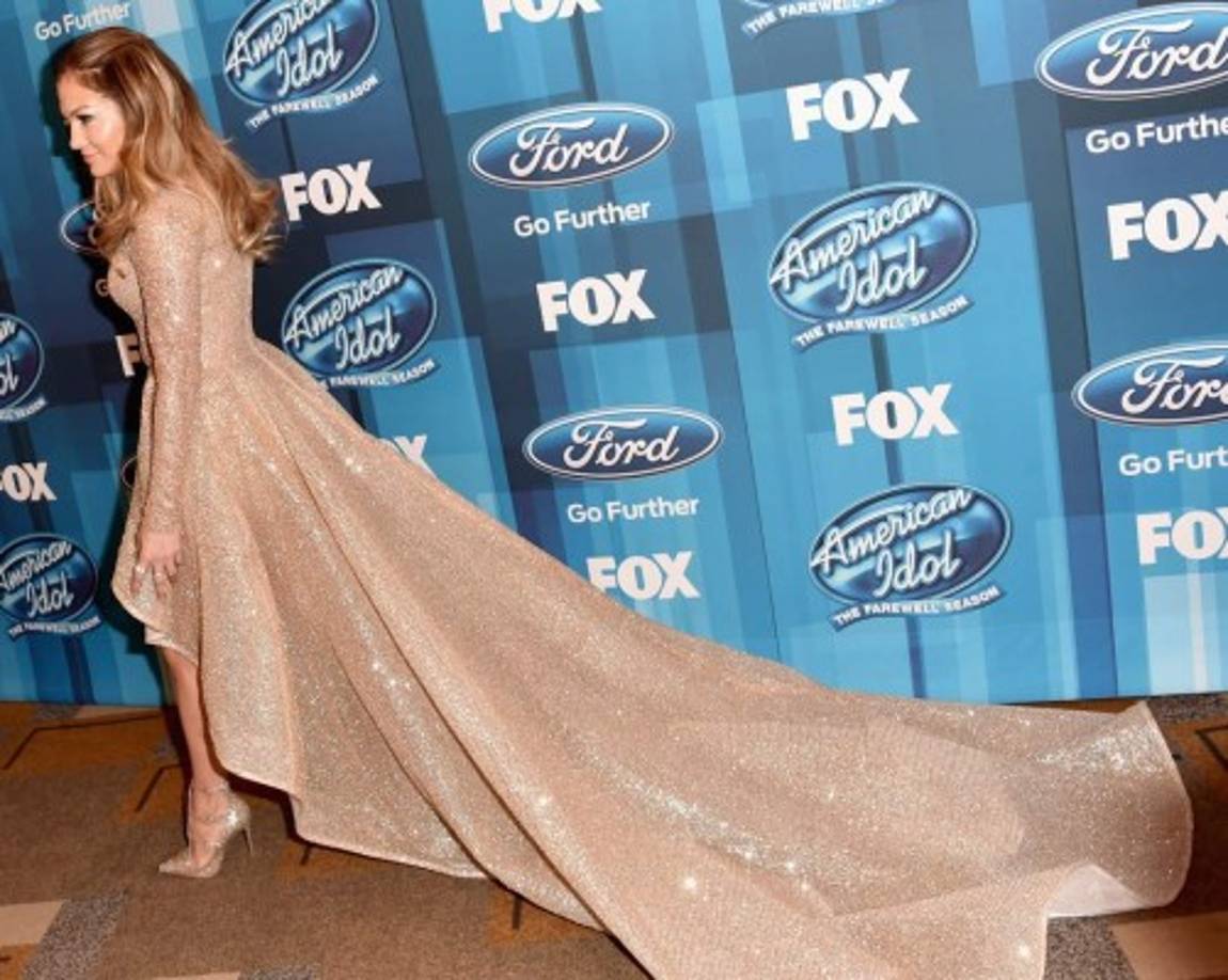 JLo sabe como ser la estrella de la noche. La diva causó sensación con un vestido de Elie Madi, encima de las rodillas y con una larga cola. Completó su look con sandalias doradas de Christian Louboutin y cabello y maquillaje naturales.