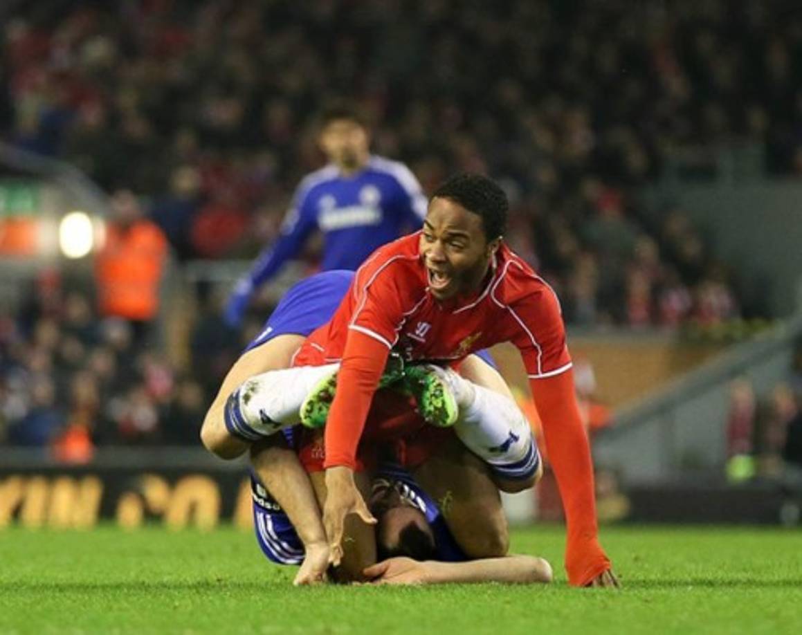 John Terry, que no se sabe si está probando una nueva pose del kamasutra o una llave de lucha libre a Raheem Sterling.