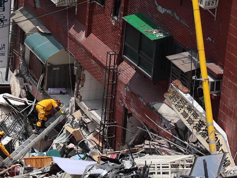 Rescatistas buscan sacar a las personas atrapadas bajo los escombros en los edificios derrumbados tras el sismo.