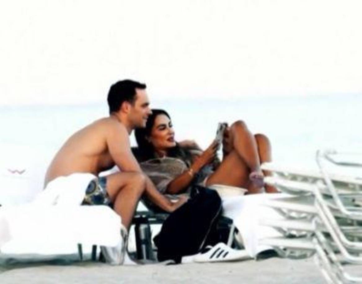 Mientras que el joven hombre se le acerca y sostiene una conversación con ella en el camastro de al lado.