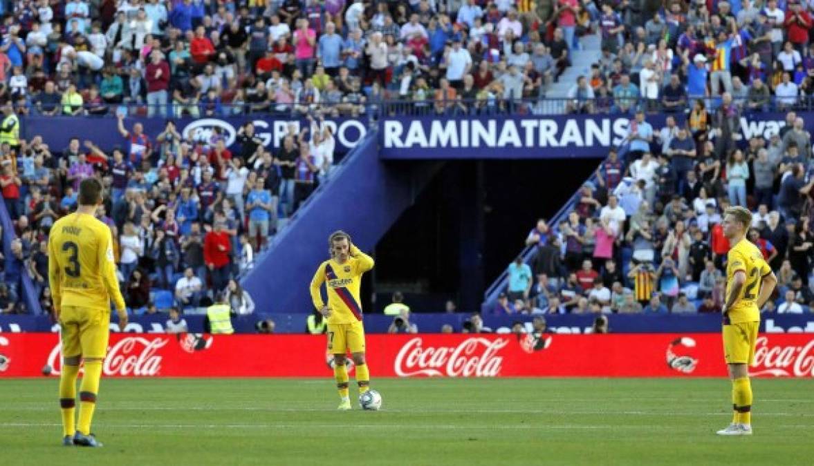 Los jugadores del Barcelona, Gerard Piqué (i), Antoine Griezmann (c) y Frenkie De Jong (d), se lamentan tras el tercer gol del Levante.