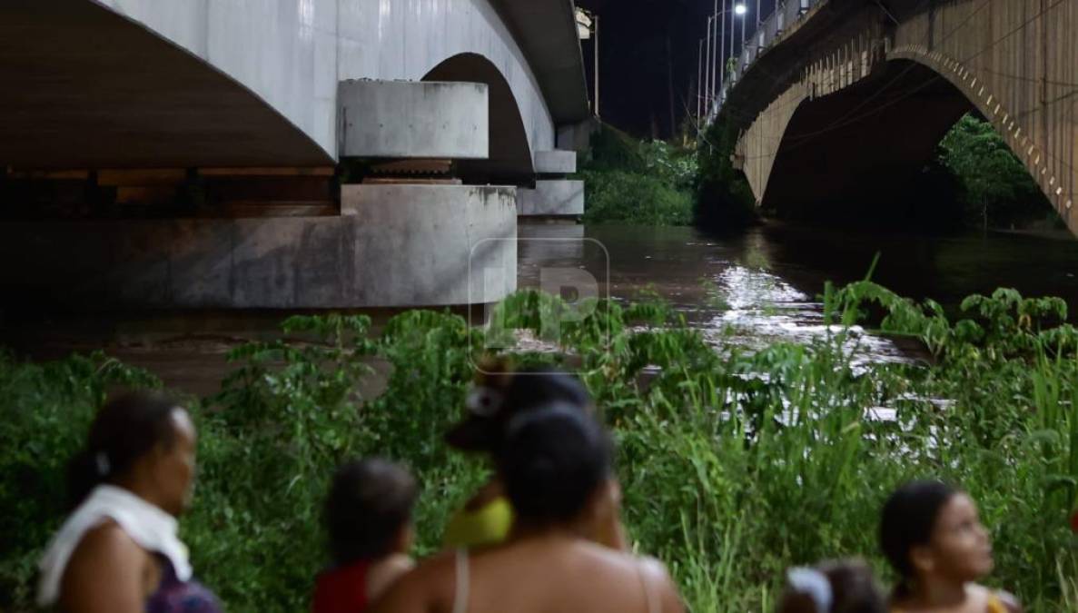 La población vigila a orillas del Ulúa el aumento en el caudal, a altas horas de la noche de este martes. 