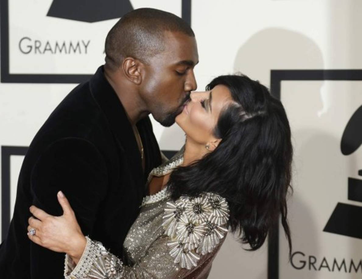 Kanye y Kim comiéndose a besos.