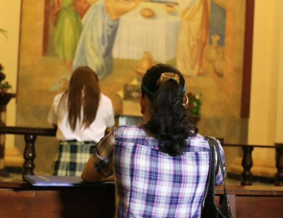 Una mujer reza ante el Santísimo en la catedral San Pedro Apóstol de San Pedro Sula después de la misa del Miércoles de Ceniza. Foto Jordan Perdomo