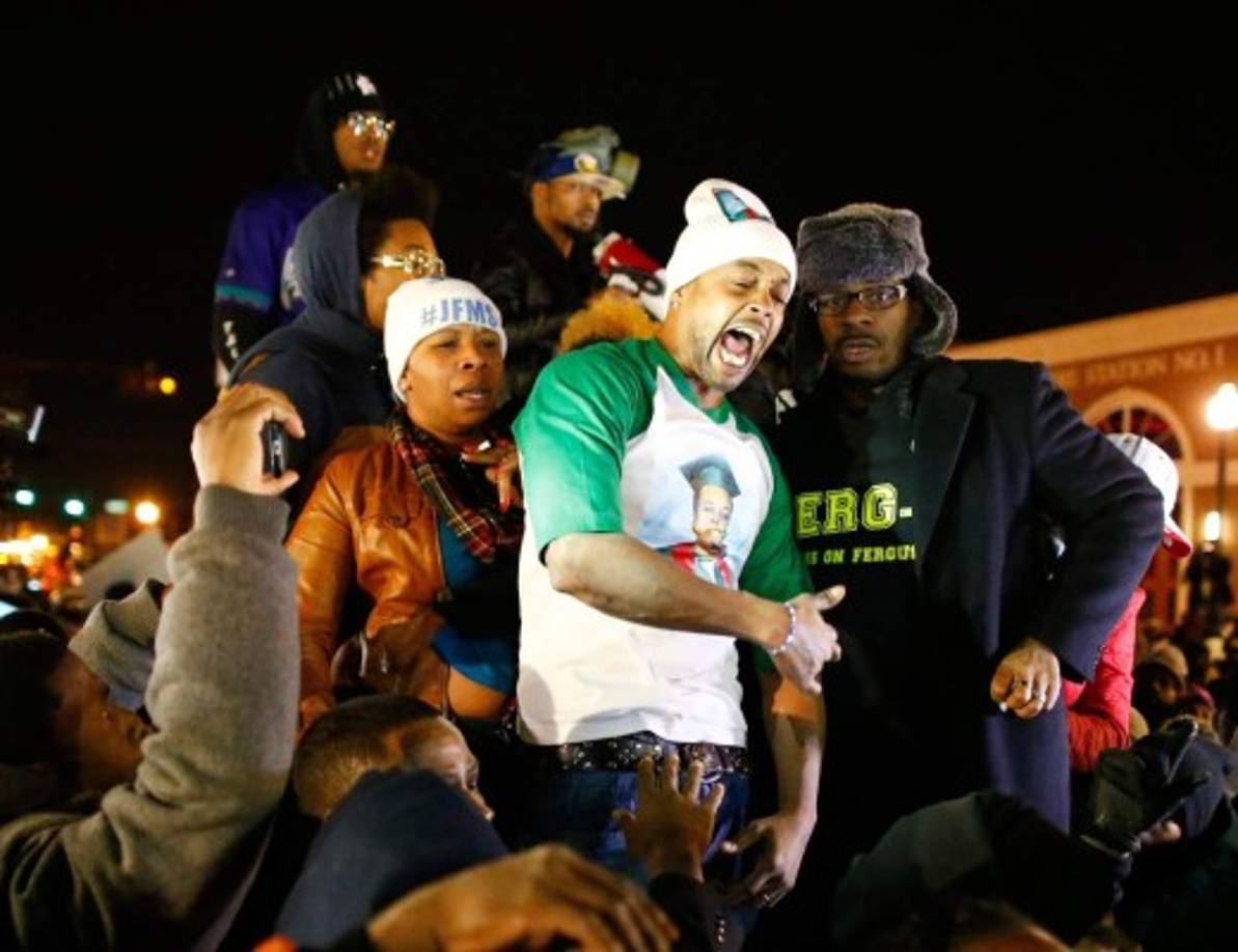 La reacción de rabia del padre de Michael Brown, de verde. La madre, detrás con gorro blanco, parece consternada.