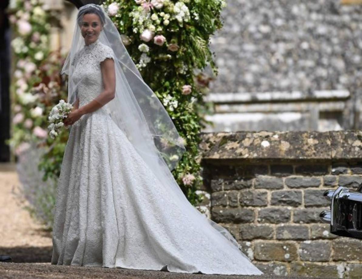 Pippa se veía radiante en un elegante vestido en color marfil del diseñador británico Giles Deacon, realizado en encaje con un ligero escote en la espalda y entallado en la cintura, que daba la impresión de ser una pieza entera sin costuras, que acompañó con velo en tul y una tiara, y zapatos de seda del español Manolo Blahnik.