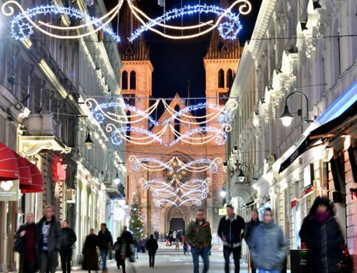 Los ciudadanos de Sarajevo se reúnen para socializar frente a la Catedral del Corazón de Jesús para celebrar la Navidad con sus amigos y vecinos católicos.