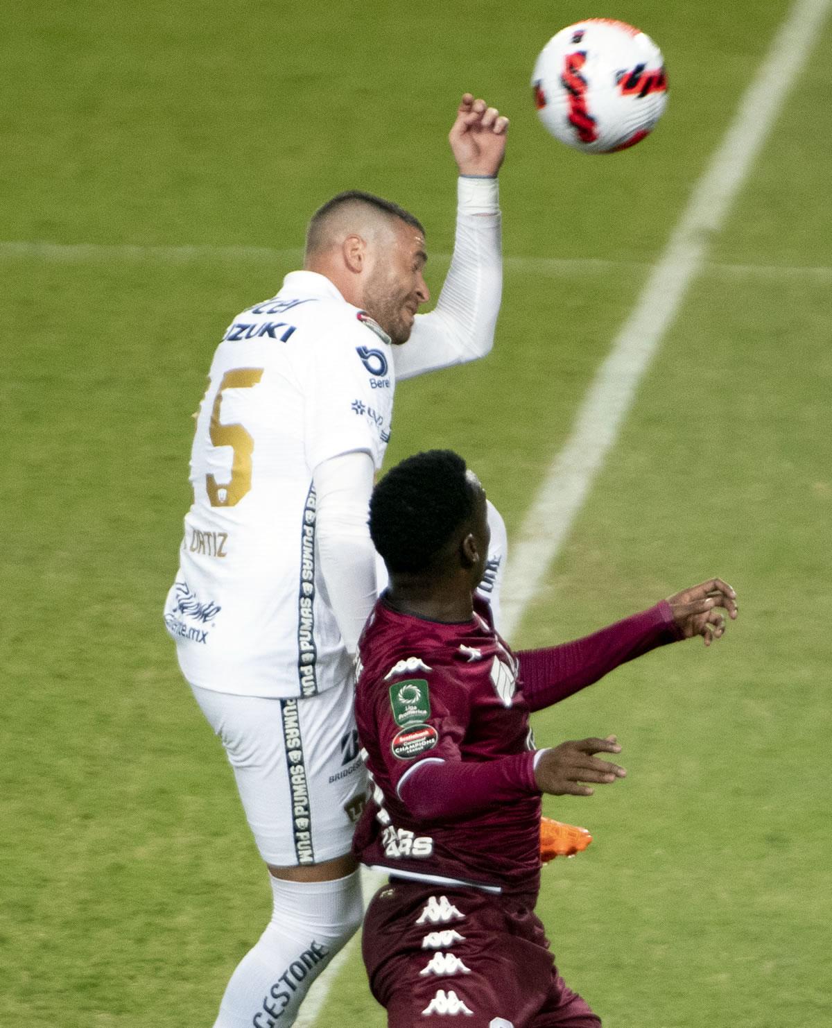 Darixon Vuelto saltando por el balón con el defensa mexicano Arturo Ortiz de Pumas.