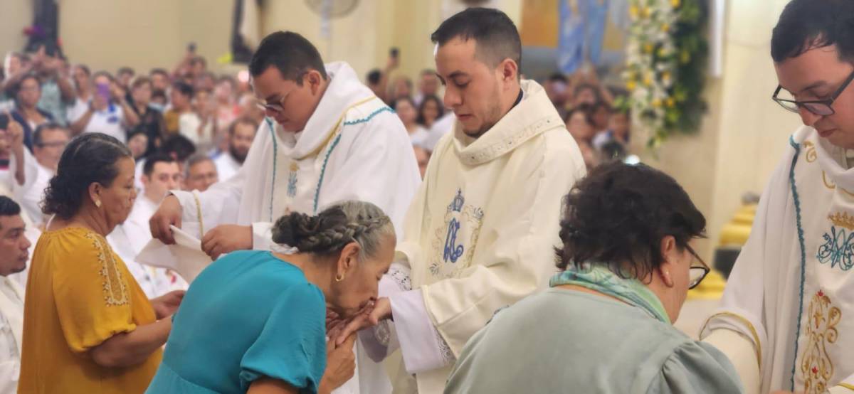 Los tres nuevos sacerdotes durante el ritual de la eucaristía.