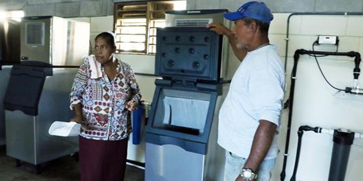 Pescadores artesanales muestran congeladores alimentados con energía renovable en Kaukira.