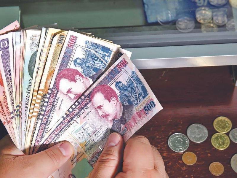 Hondureño cuenta lempiras en una entidad bancaria.