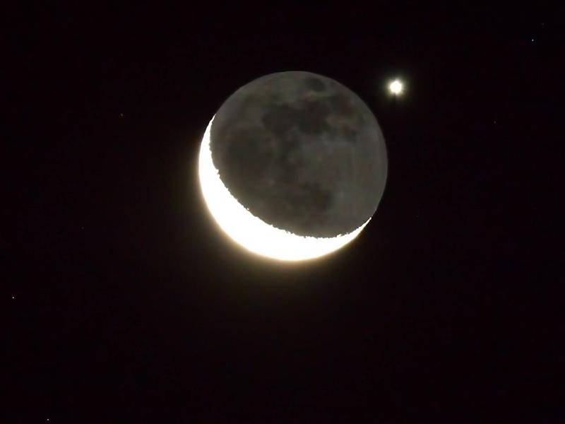 Vista del planeta Venus ocultándose tras una delgada luna creciente.