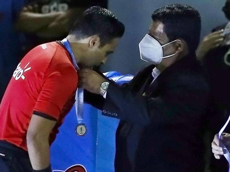 Saíd Martínez recibiendo la condecoración tras pitar la final Real España-Olimpia.