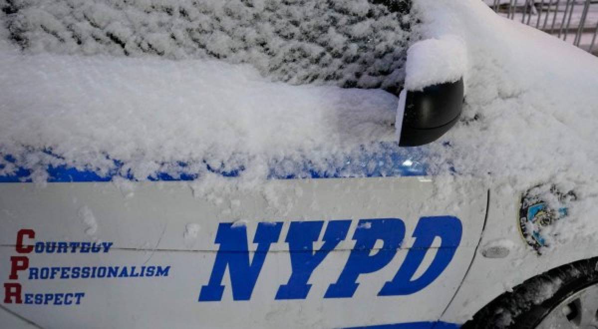 A NYPD police car is seen in the snow on December 17, 2020 in New York, the morning after a powerful winter storm hit the US northeastern states. - A major snowstorm hit the US east coast during Thursday's early hours, creating extra challenges in the midst of a coronavirus pandemic and a mass vaccination rollout taking place across the region.The winter storm, moving over New York, Pennsylvania and other northeastern states, leaves millions facing more than a foot of snow a week before Christmas, potentially disrupting coronavirus testing and delaying holiday deliveries. It also left more than 60 million people under bad weather warnings from Maine to South Carolina. (Photo by TIMOTHY A. CLARY / AFP)