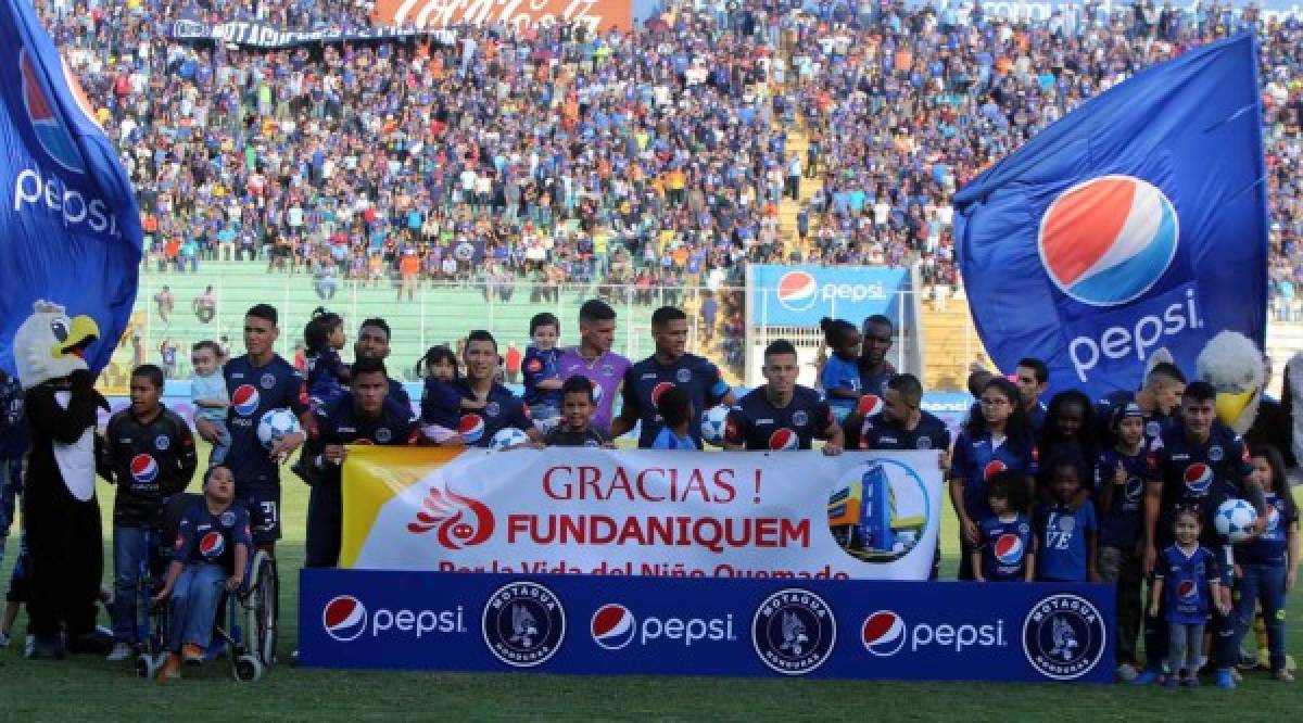 Los titulares del Motagua posando con niños y una pancarta de la Fundación Fundaniquem.