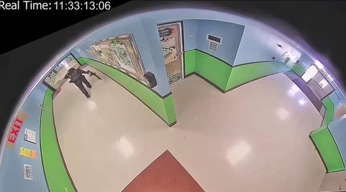 Mientras camina por un pasillo vacío, un niño lo ve desde una esquina y huye mientras el tirador abre fuego dentro de un aula.