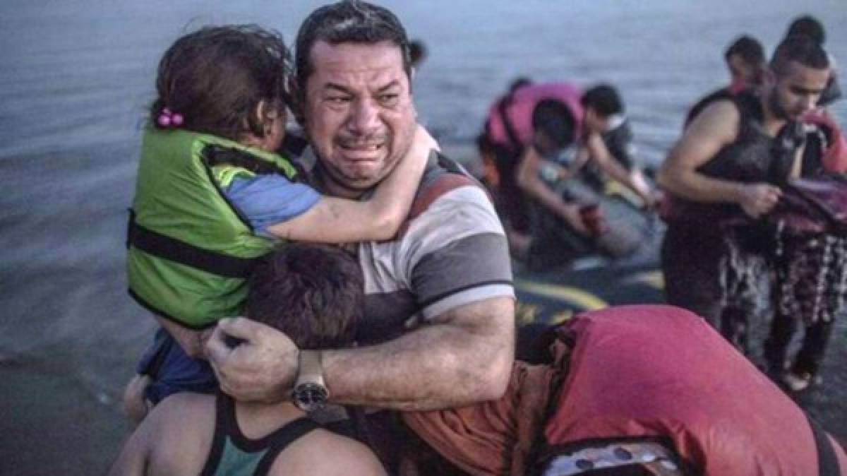 El sirio Laith Majid cargando a su hijo y a su hija en brazos, luego de un viaje de Turquía a la isla griega de Kos en un bote inflable que estaba perdiendo aire continuamente durante el trayecto conmovió a miles.