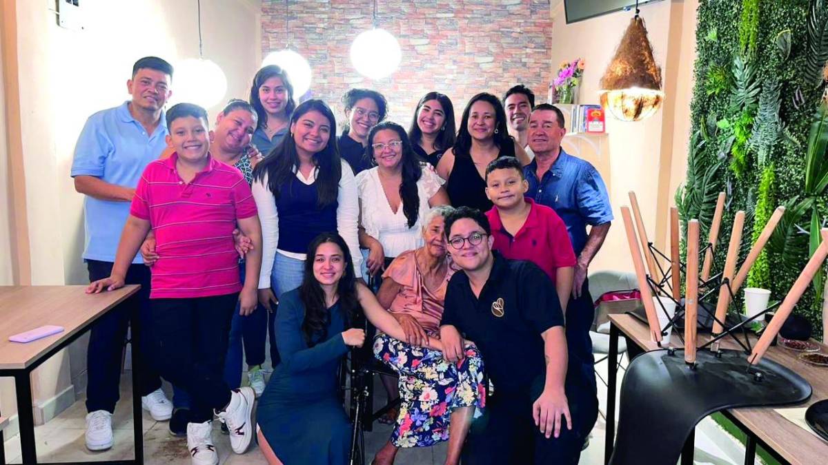 Los jóvenes emprendedores posan con familiares y amigos tras finalizar el primer día de operaciones de la cafetería.