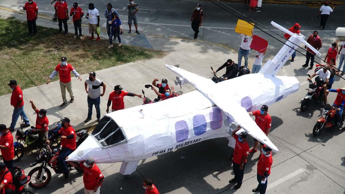 En la marcha del Primero de Mayo llevaron un avión de cartón simbolizando la extradición de hondureños.