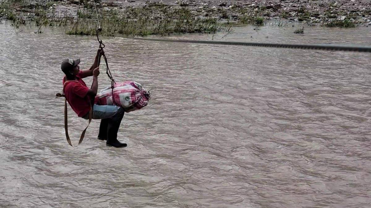 Un hombre traslada mercadería por el cable.