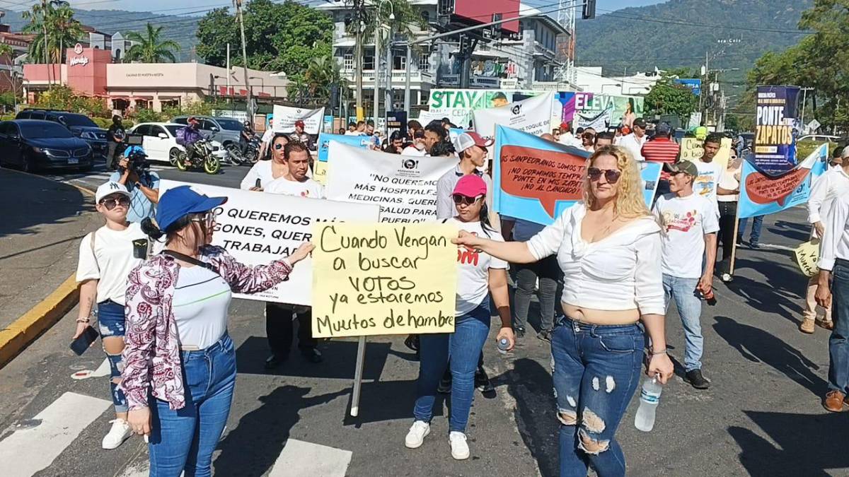 Algunas de las pancartas que portan los manifestantes contra la medida del toque de queda en San Pedro Sula.