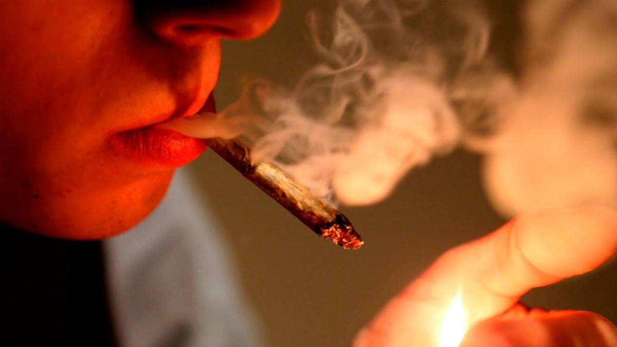 Persona echándose su porro de cannabis con música de Bob Marely de fondo.